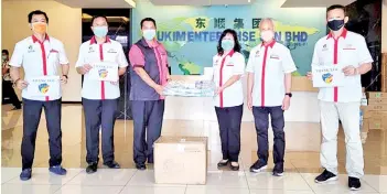  ??  ?? Siew Ling (third right) hands over the PPE to Kong. Also seen are Liew (second right) and, from left, Kwan, Kok Jyh and Chiew.