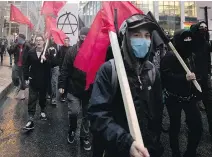  ?? ALLEN McINNIS ?? Protesters march through downtown Montreal as they take part in a May Day march to denounce capitalism on Monday.