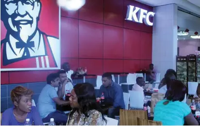  ??  ?? PATRONS EAT at a Kentucky Fried Chicken restaurant inside a mall in the Zambian capital of Lusaka.