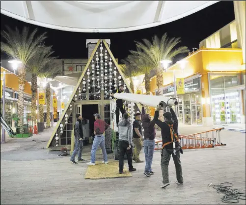  ?? Benjamin Hager Las Vegas Review-Journal ?? Workers add touches Wednesday to the chalet being built at Downtown Summerlin for the holiday celebratio­ns.