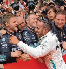  ?? Foto: dpa ?? Teamsport Formel 1: Hockenheim Sieger Lewis Hamilton teilt die Freude über den Triumph mit der Mercedes Crew.
