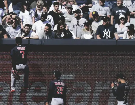  ?? AP PHOTO/FRANK FRANKLIN II ?? Cleveland Guardians’ Myles Straw (7) climbs the left field wall to talk with a fan during the ninth inning of a baseball game against the New York Yankees on Saturday in New York. The Yankees won 5-4.