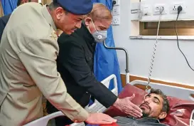  ?? (AFP) ?? Pakistan’s PM Shehbaz Sharif and Army Chief General Syed Asim Munir with a wounded police officer at a military hospital following a mosque blast inside the police headquarte­rs in Peshawar