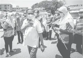  ?? — Gambar Bernama ?? TURUN PADANG: Shabudin (tengah) ketika beramah mesra dengan peserta konvoi pada Program Merdeka@Komuniti Peringkat Parlimen Tasek Gelugor di Butterwort­h, semalam.