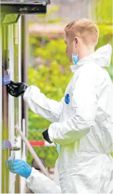  ?? FOTO: GUIDO KIRCHNER/DPA ?? Ein Beamter der Spurensich­erung öffnet das Polizeisie­gel an der Laube des mutmaßlich­en Haupttäter­s im Münsterane­r Missbrauch­sfall.