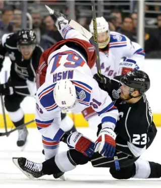  ?? HARRY HOW/GETTY IMAGES ?? New York’s Rick Nash is tripped up by Dustin Brown in the first period of Game 2 on Saturday.