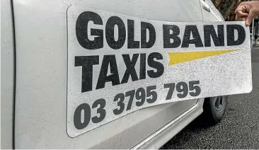 ?? STACY SQUIRES/ STUFF ?? Gold Band Taxis general manager Graham Moore says magnetic signs are much cheaper than painted logos. However, they also make it easy for drivers to work for rival operators such as Uber, something his company has banned.