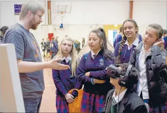  ??  ?? Caitlin Rapira, Faith Peseta, Tylar Peratiaki, and Tali Morehu-Prime from Naenae College listen to Byron Mallett from the School of Design at Victoria University explaining 3-D imaging technology. Taking in the virtual world with goggles is Jaxson...