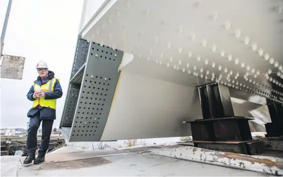  ??  ?? Johnson Street Bridge project director Jonathan Huggett with the main bridge deck-span counterwei­ght.