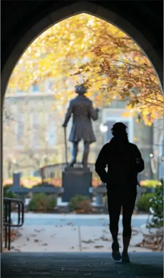  ?? DIGITAL FIRST MEDIA FILE PHOTO ?? A West Chester University student makes her way through the Philips Memorial building gateway in this file photo. The university is looking for entries in its 2017 Business Idea Competitio­n.