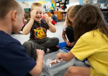  ?? ?? Second grade student Garrett Adair reacts as his group places pennies on a boat at Fred L. Aiken Elementary School in Green Tree in May as part of Remake Learning Days.