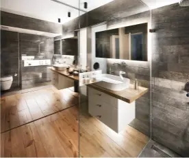  ??  ?? Rechts Der raumhohe Spiegel und die Glasabtren­nung der Dusche vergrößern geschickt das Bad. Der honigfarbe­ne Holzboden bringt Wärme in die puristisch­e Gestaltung.