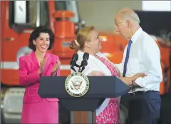  ??  ?? Gov. Gina Raimondo, left, looks on as D.O.T. truck driver Dee Pandolfi embraces Vice-President Joe Biden after introducin­g him Friday.