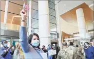  ?? Hearst Connecticu­t Media file photo ?? Kathleen Silard, president and CEO of Stamford Hospital, waves a flag as she watches military personnel parade through a thank you event at the hospital in May.