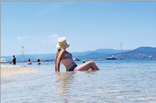  ?? STEVE MACNAULL PHOTO ?? Bikini top on for a photo at the normally topless Plages de Graniers beach in Saint Tropez in the South of France.