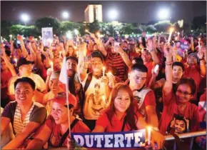  ?? TED ALJIBE/AFP ?? Supporters of Philippine President Rodrigo Duterte raise candles during a rally at a park in Manila on Saturday coinciding with the ‘People Power’ revolution anniversar­y.