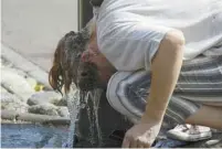  ?? BOB EDME ASSOCIATED PRESS ?? Une femme tente de se rafraîchir dans une fontaine à Saint Jean de Luze, dans le sud-ouest de la France.