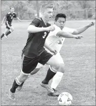  ?? Photo by Mike Eckels ?? Gentry’s Clay Wills (3) moves the ball downfield while Decatur’s Alexis Gramajo (11) tries to intercept during the Decatur-Gentry soccer match at Bulldog Stadium in Decatur on April 13.