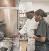  ?? ASHLEE REZIN/SUN-TIMES ?? Ashlee White, 23, participat­es in a Before The Plate training session with Claude Ako, executive chef of Rome’s Joy Catering, at Parkway Ballroom on Aug. 21.