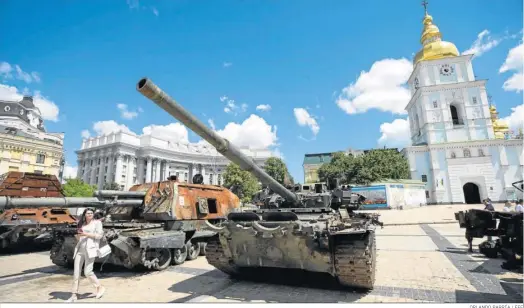  ?? ORLANDO BARRÍA / EFE ?? Personas recorren la exhibición de tanques rusos destruidos, que están instalados en la plaza San Miguel, en Kiev.