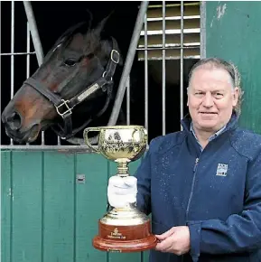  ?? LAWRENCE GULLERY ?? Rich Hill stud managing director, John Thompson holds the Melbourne Cup next to Shocking, which won the Cup in 2009.