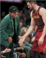  ?? JULIE JACOBSON — THE ASSOCIATED PRESS ?? Cavaliers center Kevin Love (0) greets Masters winner Patrick Reed during a timeout at a game against the Knicks Monday in New York.