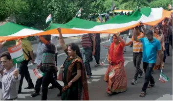  ?? — BIPLAB BANERJEE ?? People march with 2,200 -feet-long tricolour to mark Kargil Vijay Diwas on JNU campus in New Delhi on Sunday. The programme, which was jointly organised by JNU and “Veterans India” for the first time, also saw 23 families of the martyrs, Union...