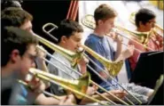  ?? BOB RAINES — DIGITAL FIRST MEDIA ?? John Hutchings, center, practices with the trombone section for the New Orleans Jazz Fest.