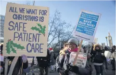  ?? REUTERS ?? Demonstrat­ors hold placards on a picket line during a strike by NHS nursing staff outside St. Thomas’ Hospital in London last Thursday.