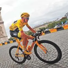  ?? AP ?? Chris Froome followed by teammate Vasil Kiryenka as they pass the Arc de Triomphe in the last stage of the Tour on Sunday.