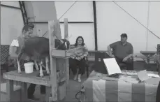  ?? File photo ?? Evie Neubauer demonstrat­es how you milk a goat for Brooks MLA Michaela Glasgo and Premier Jason Kenney as part of a Canada Day visit this year.