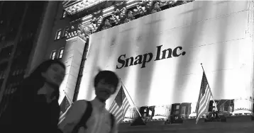  ??  ?? A Banner for Snap Inc hangs on the facade of the the New York Stock Exchange (NYSE) on the eve of the company’s IPO in New York. The mobile applicatio­n Snapchat became a social media star with messages that vanish after viewing, making co-founders Evan Spiegel and Bobby Murphy among the youngest billionair­es on the planet.