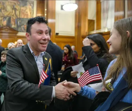  ?? Steve Mellon/Post-Gazette ?? Ian Jordan, left, a native of Colombia, receives congratula­tions on becoming a U.S. citizen after a naturaliza­tion ceremony Friday at the federal courthouse. During the ceremony, 51 people from 31 countries were naturalize­d.