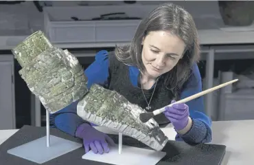  ?? PICTURE: DUNCAN MCGLYNN/NATIONAL MUSEUMS SCOTLAND/PA ?? Conservato­r Bethan Bryan with the reconstruc­et piece of Roman armour from the second century