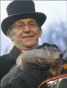  ??  ?? Groundhog Club co-handler Ron Ploucha holds Punxsutawn­ey Phil on Groundhog Day 2016.