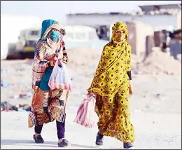  ??  ?? This file photo shows Sahrawi women walking on a gravel road in the Smara refugee camp in Algeria’s Tindouf province. Tens of thousands of Sahrawis live as refugees in the west of Algeria, while some of their relatives remained hundreds of kilometres...