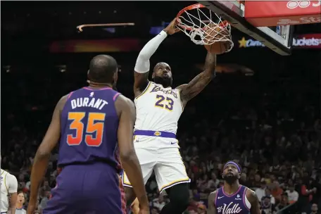  ?? RICK SCUTERI — THE ASSOCIATED PRESS ?? Los Angeles Lakers forward LeBron James (23) dunks over Phoenix Suns forward Kevin Durant (35) and forward Royce O’Neale during the first half of an NBA basketball game, Sunday, Feb. 25, 2024, in Phoenix.