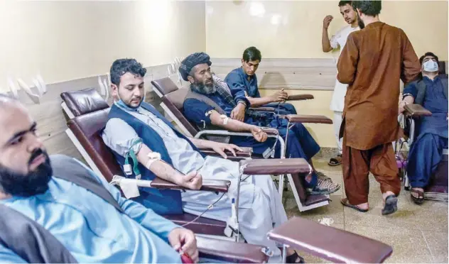  ?? Agence France-presse ?? ↑ Men donate blood for people who got injured during clashes between Taliban and government forces in Kandahar on Monday.