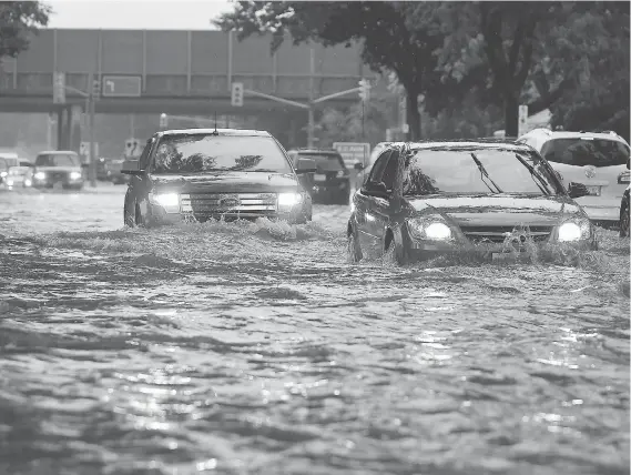  ?? JASON KRYK ?? Cars barely make it down Dominion Boulevard in South Windsor during heavy rain on Aug. 29 — the worst flooding event in the city’s history.