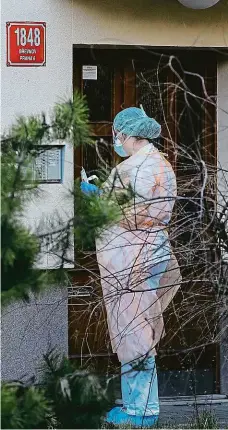  ?? Foto: Michal Sváček, MAFRA ?? Rychlý odběr Zdravotnic­e, která jezdí se sanitou a dělá odběry vzorků na virus, čeká před domem pacienta v Praze.