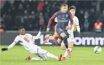  ??  ?? Paris Saint-Germain’s French forward Kylian MBappe runs on his way to score a last second goal during the French L1 football match between Paris Saint-Germain and Lille at the Parc des Princes stadium in Paris. — AFP photo