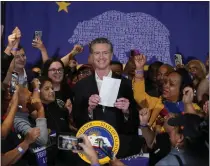  ?? DAMIAN DOVARGANES – THE ASSOCIATED PRESS ?? Gov. Gavin Newsom signs the fast food bill surrounded by fast-food workers at the SEIU Local 721 in Los Angeles on Sept. 28. Republican leaders in California are calling for an investigat­ion into why a new state law requiring a $20minimum wage for fast food workers includes an exemption for restaurant­s like Panera Bread.