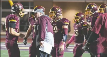  ?? The Sentinel-Record/Grace Brown ?? SIDELINE CHAT: Lake Hamilton head coach Tommy Gilleran talks with quarterbac­k Layne Warrick (12), left, during a break in the action in Friday night’s game against Russellvil­le at Bank OZK Field. The Wolves won, 42-7.