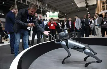  ?? ?? Visitor watch Tecno’s Chinese company’s ‘Dynamic 1’ robotic dog during the MWC in Barcelona.