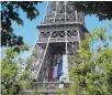  ??  ?? The French national flag adorns the Eiffel Tower.