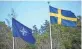  ?? FREDRIK SANDBERG/ TT NEWS AGENCY/AFP ?? The NATO flag, left, is raised next to a Swedish flag at a ceremony in Stockholm on Monday.