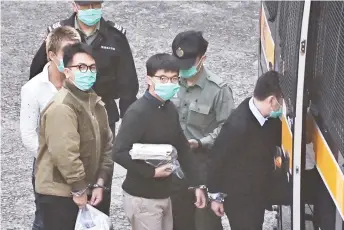  ?? — AFP photo ?? Wong (centre) and Lam (left) board a police van at Lai Chi Kok Reception Centre in Hong Kong before going to court to be sentenced.