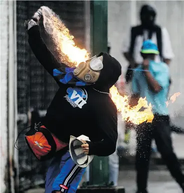  ?? FEDERICO PARRA / AFP / GETTY IMAGES ?? An opposition activist clashes with riot police during a demonstrat­ion against the government of President Nicolas Maduro in Caracas on Monday.