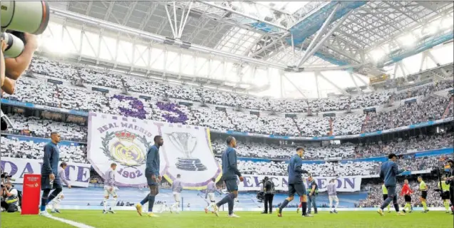  ?? ?? Los jugadores del Barça saltan al campo junto a los del Real Madrid durante el Clásico de Liga de la temporada pasada en el Bernabéu.