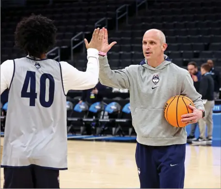  ?? STUART CAHILL/BOSTON HERALD ?? UConn Huskies head coach Dan Hurley greets guard Andre Johnson Jr. (40) during practice Wednesday at the TD Garden in preparatio­n for Sweet 16games.